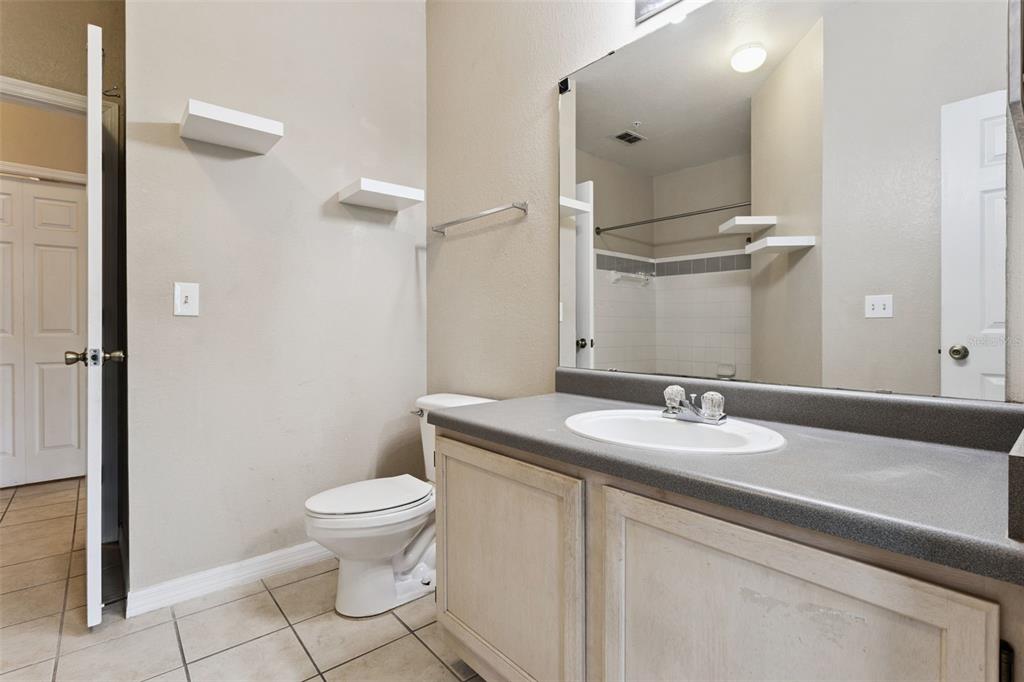 3446 Soho Street, Unit 303 Orlando, FL 32835 - Photo 23 of 47 a bathroom with a granite countertop sink a toilet and a mirror