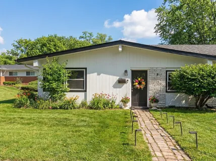 a living room with furniture and painting on the wall next to a window