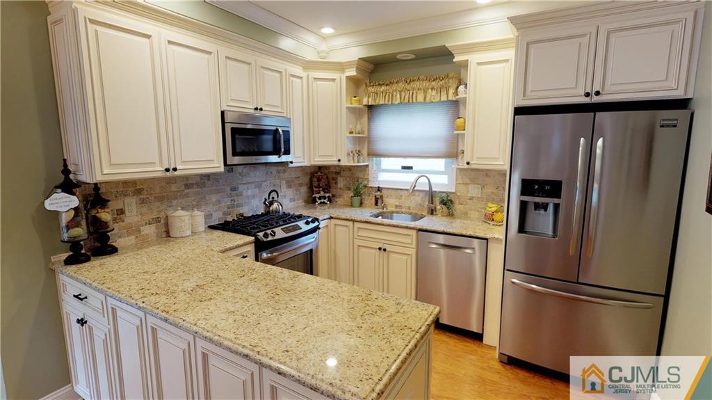 16 Sweet Gum Road Howell, NJ 07731 - Photo 6 of 21 a kitchen with stainless steel appliances granite countertop a refrigerator stove microwave and sink