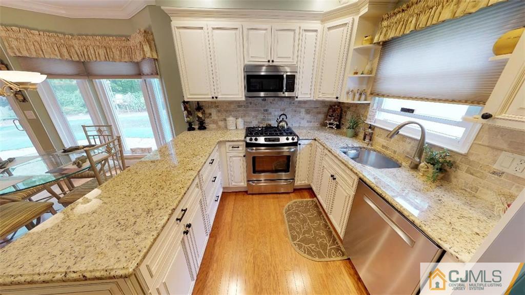 16 Sweet Gum Road Howell, NJ 07731 - Photo 7 of 21 a kitchen with a stove a sink and a microwave
