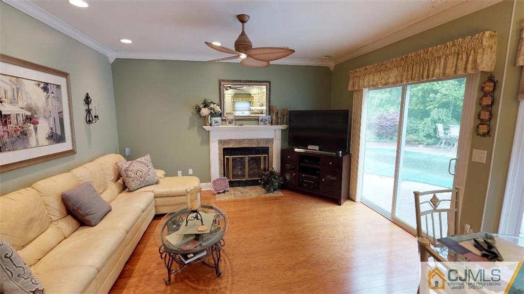16 Sweet Gum Road Howell, NJ 07731 - Photo 9 of 21 a living room with furniture a fireplace and a flat screen tv