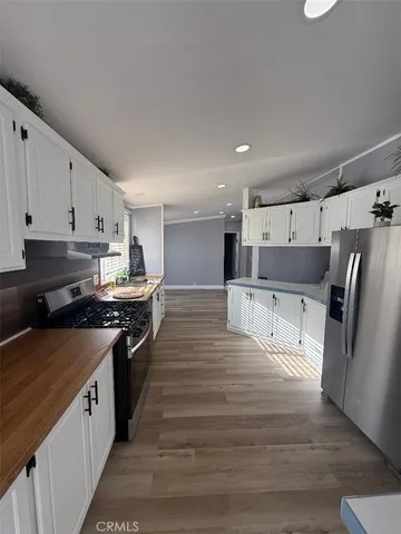 a large kitchen with stainless steel appliances granite countertop a stove and a refrigerator