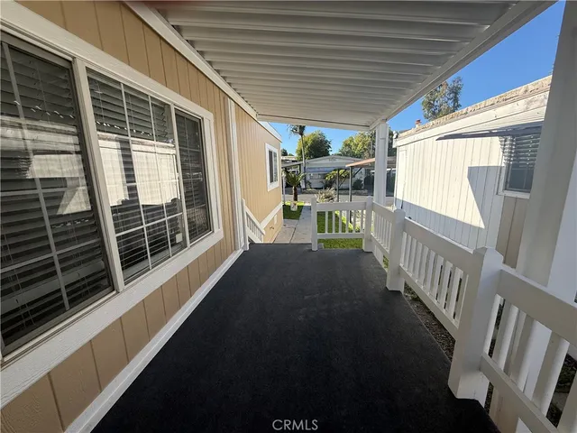 a view of a porch with wooden floor and iron stairs