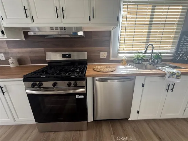 a kitchen with stainless steel appliances granite countertop a sink stove and cabinets