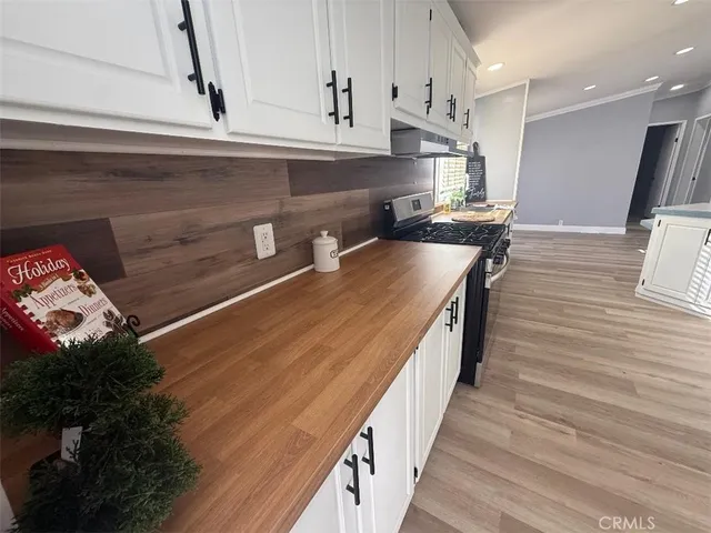 a kitchen with granite countertop a stove a sink and a refrigerator