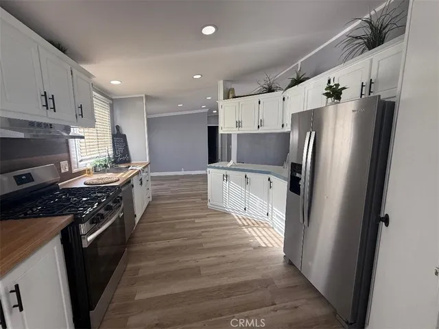 a kitchen with stainless steel appliances a refrigerator a stove top oven and sink