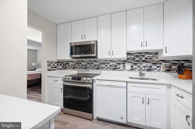 a kitchen with white cabinets and stainless steel appliances