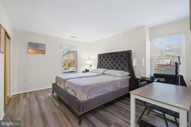 a bedroom with a bed and wooden floor