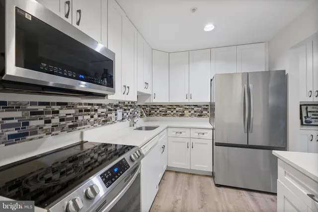 a kitchen with granite countertop a sink stove and refrigerator