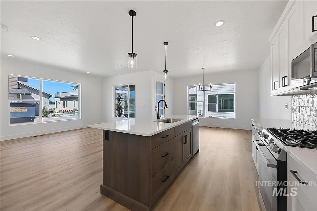 776 South Calhoun Lane Star, ID 83669 - Photo 10 of 49 Open-concept kitchen featuring a large island with sink, stainless steel appliances, and wood-finish flooring