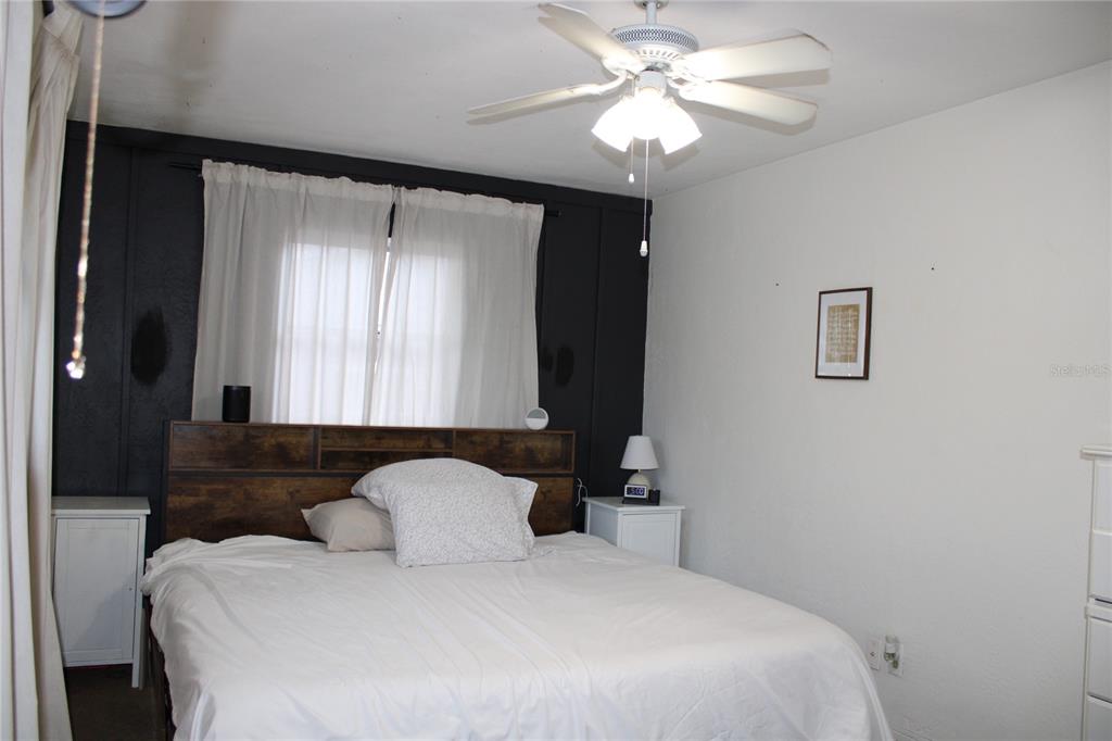 11364 79th Avenue Seminole, FL 33772 - Photo 14 of 28 a bedroom with a large bed and a chandelier