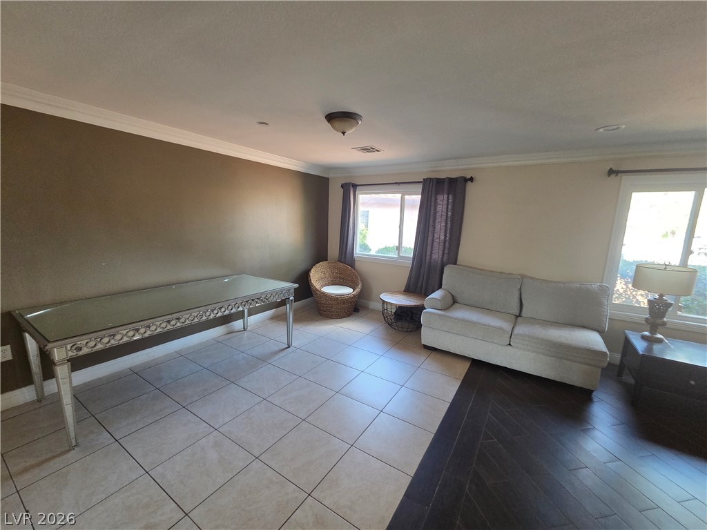 3381 Westwind Road Las Vegas, NV 89146 - Photo 15 of 52 Well-lit living area featuring diverse flooring and elegant crown molding.