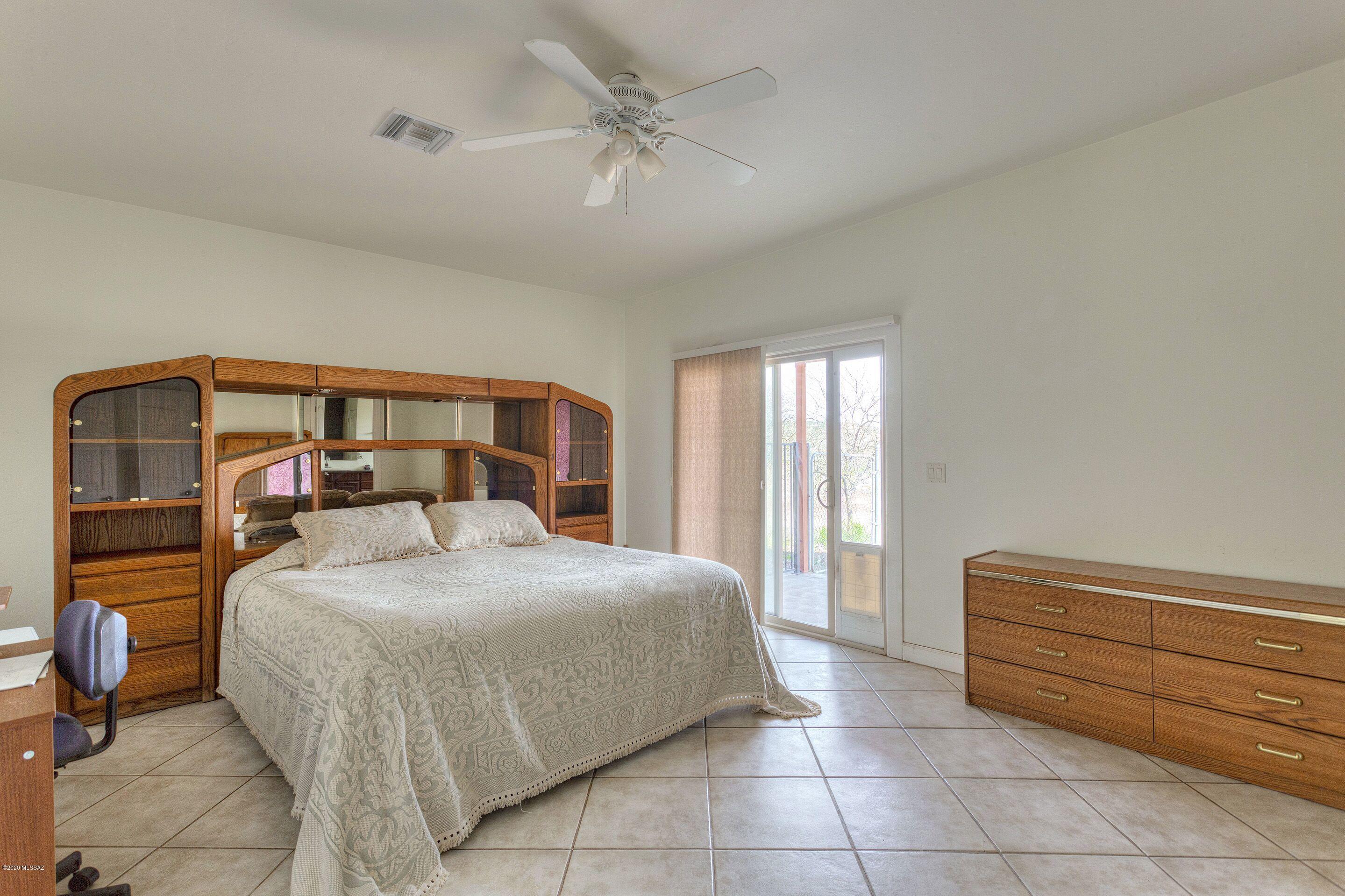 1253 Calle Tubatana Rio Rico, AZ 85648 - Photo 11 of 22 a bedroom with a bed and a chandelier