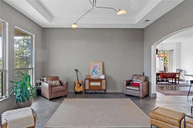 a bedroom with a bed and large windows
