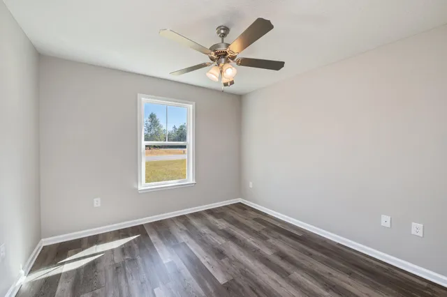 an empty room with a window and a fan