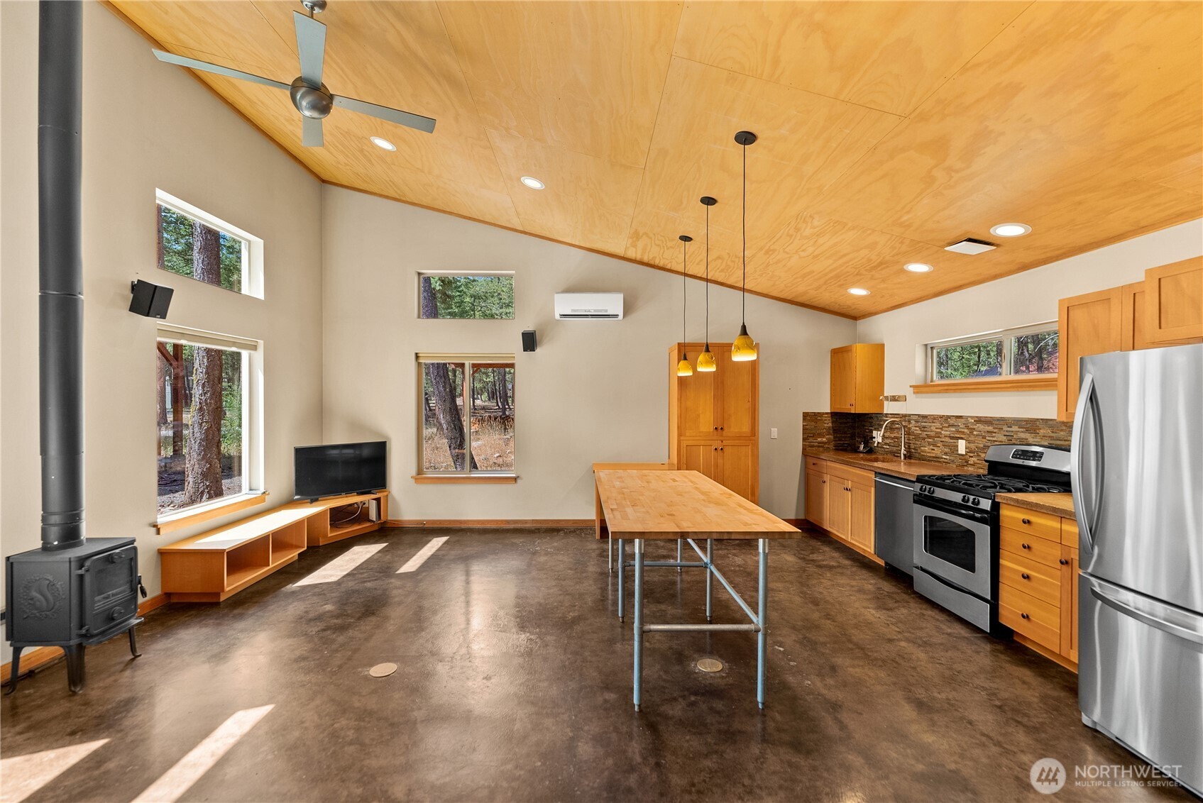 16 Littell Road Mazama, WA 98833 - Photo 29 of 40 a kitchen with stainless steel appliances kitchen island granite countertop a stove a refrigerator a oven a dining table and chairs with wooden floor