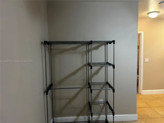 a view of a livingroom with an empty kitchen space and a window