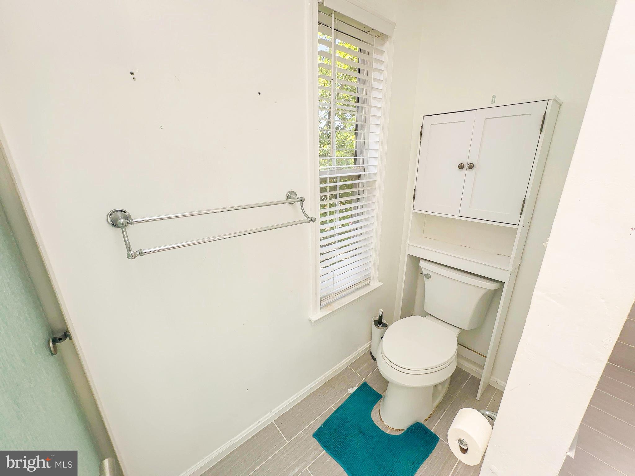 7403 Hawthorne Street Landover, MD 20785 - Photo 34 of 39 a white toilet sitting next to a shower curtain
