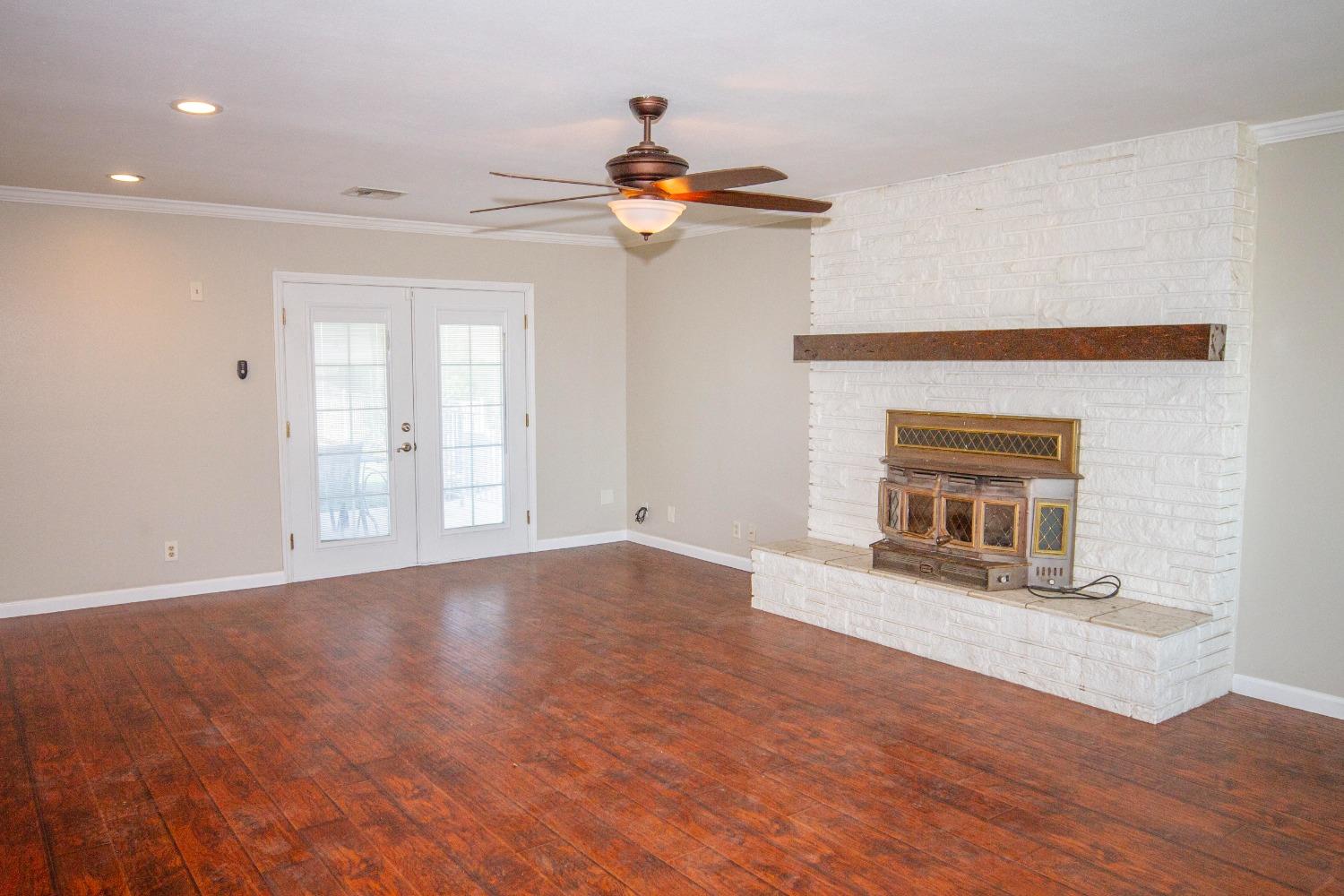 5357 South Hills Valley Road Orange Cove, CA 93646 - Photo 12 of 55 a view of empty room with wooden floor and fireplace