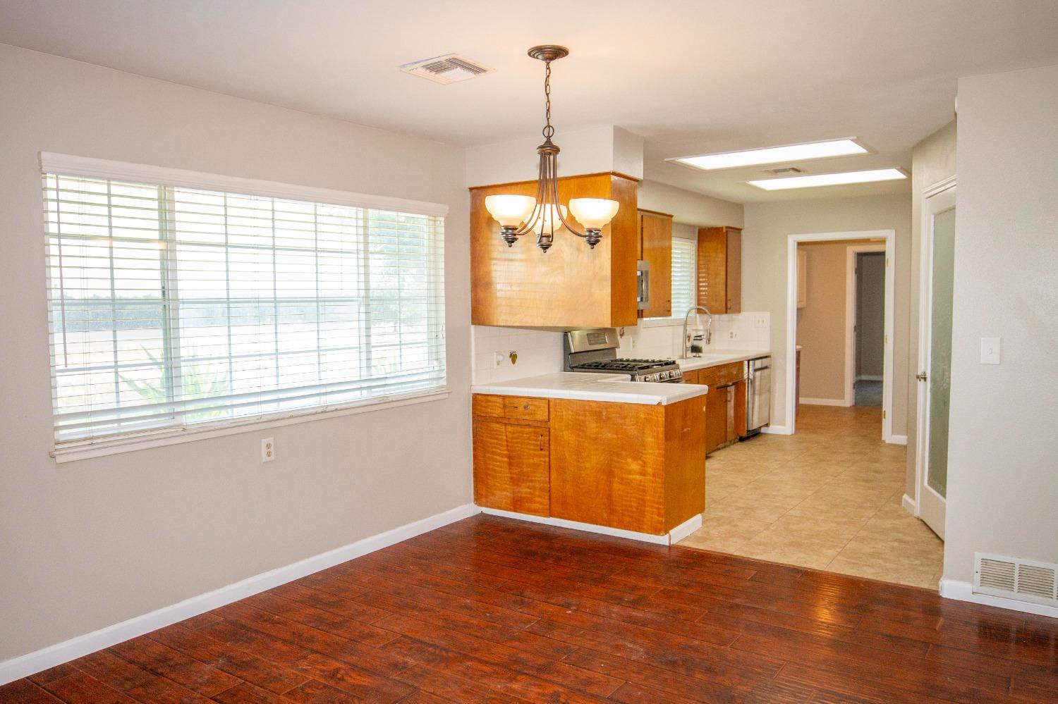 5357 South Hills Valley Road Orange Cove, CA 93646 - Photo 13 of 55 a kitchen with kitchen island granite countertop a stove a sink a refrigerator dining table and chairs