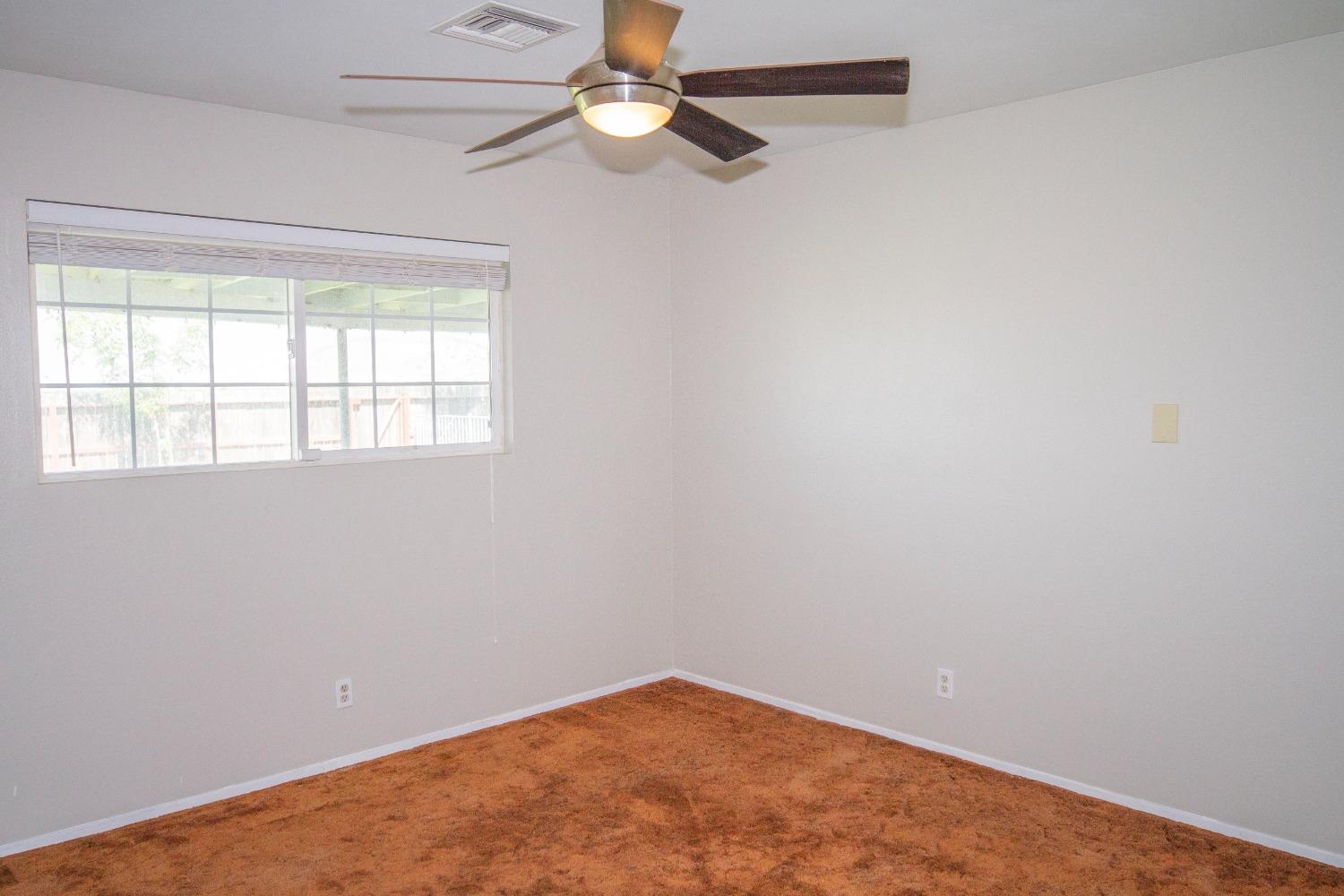 5357 South Hills Valley Road Orange Cove, CA 93646 - Photo 17 of 55 an empty room with a window and a fan