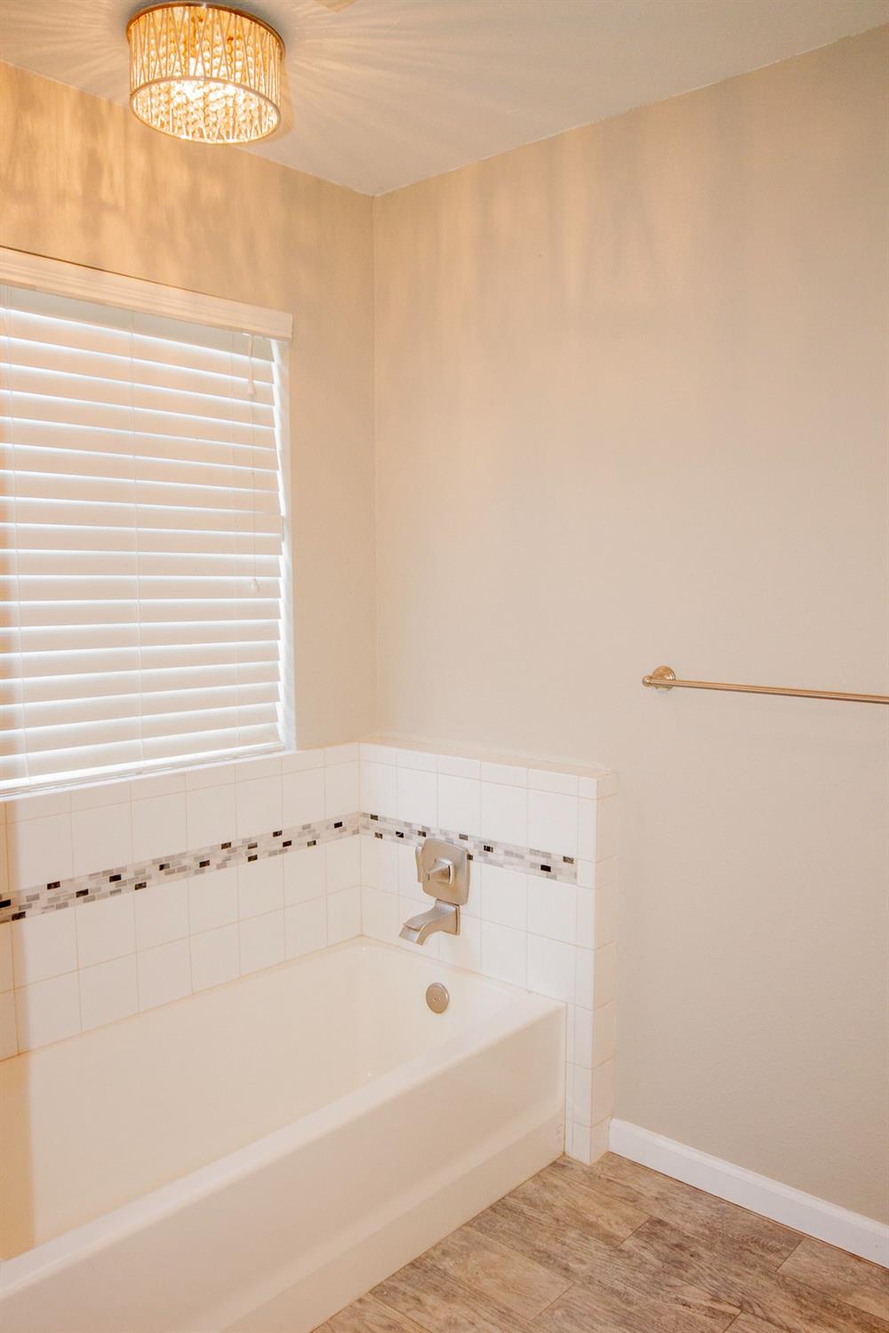 5357 South Hills Valley Road Orange Cove, CA 93646 - Photo 24 of 55 a bathroom with a bathtub and a window