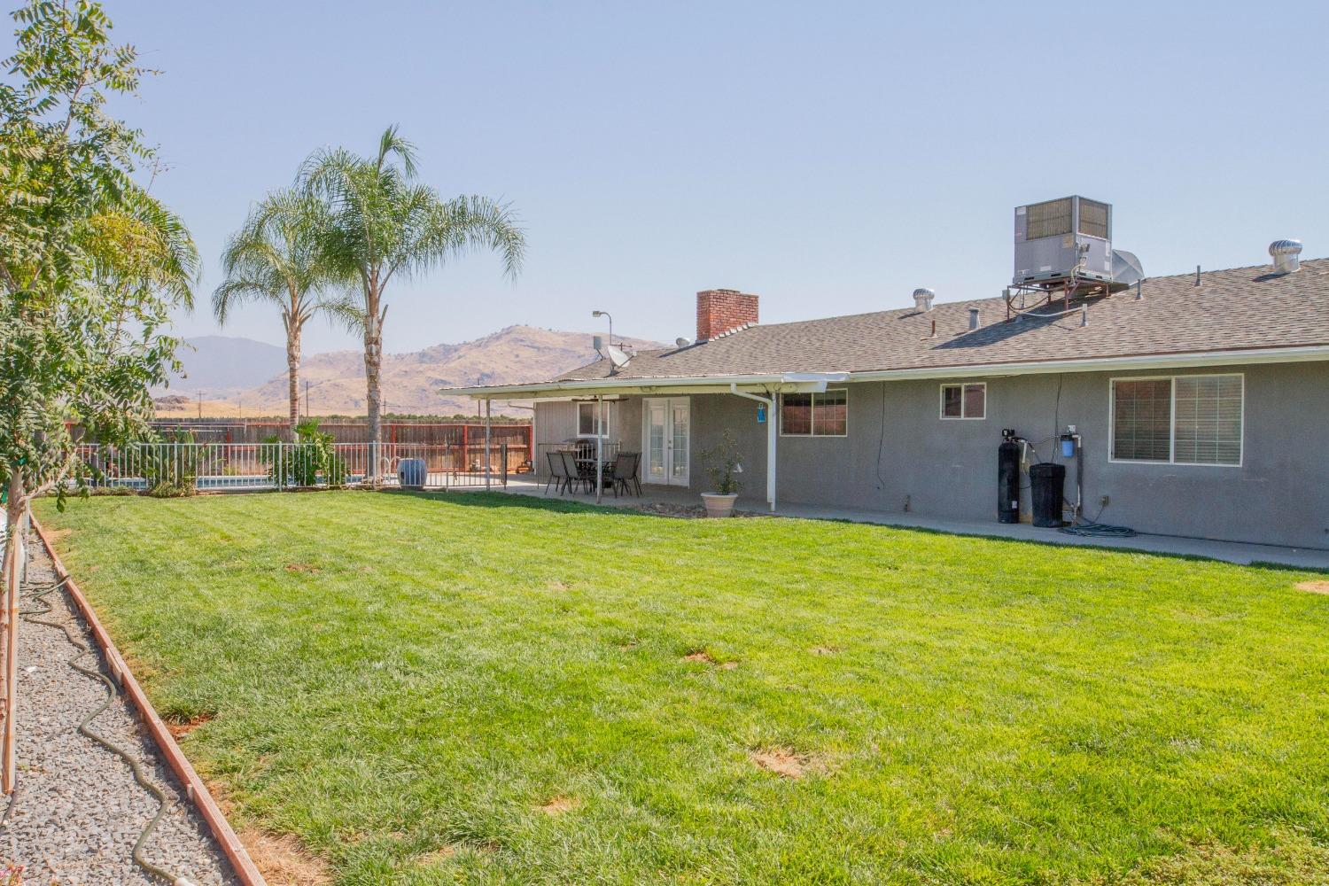 5357 South Hills Valley Road Orange Cove, CA 93646 - Photo 8 of 55 a view of a house with a backyard and a patio