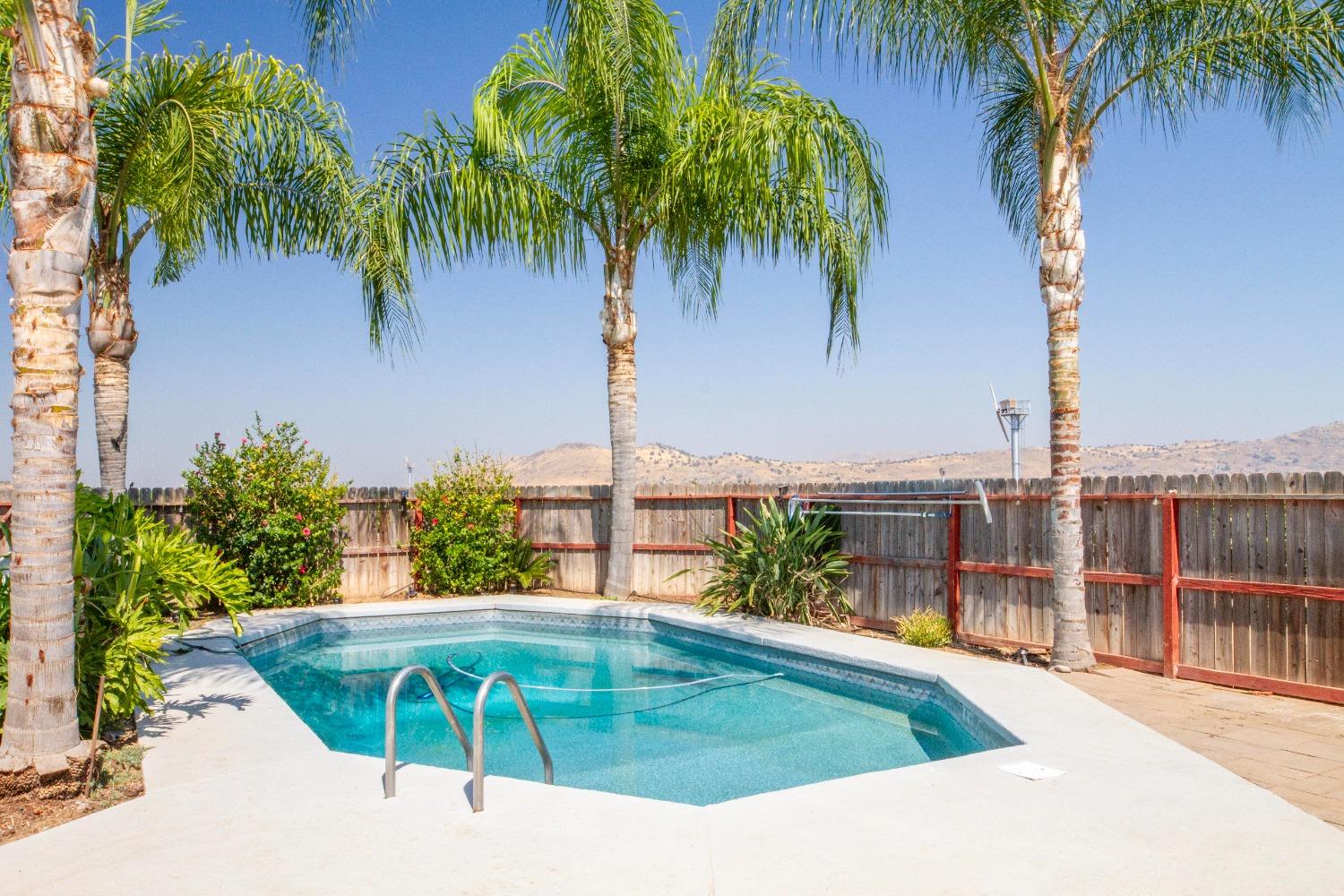 5357 South Hills Valley Road Orange Cove, CA 93646 - Photo 9 of 55 a view of a swimming pool with a garden