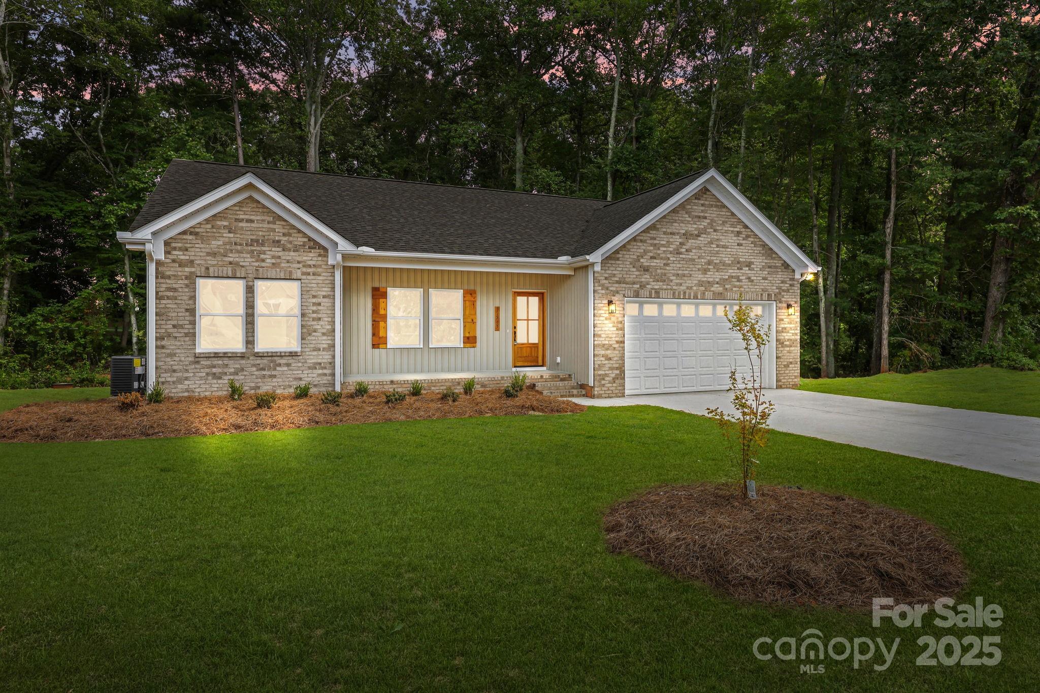 a front view of a house with a yard and trees