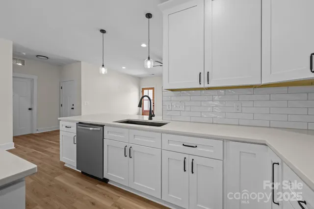 a kitchen with white cabinets and sink
