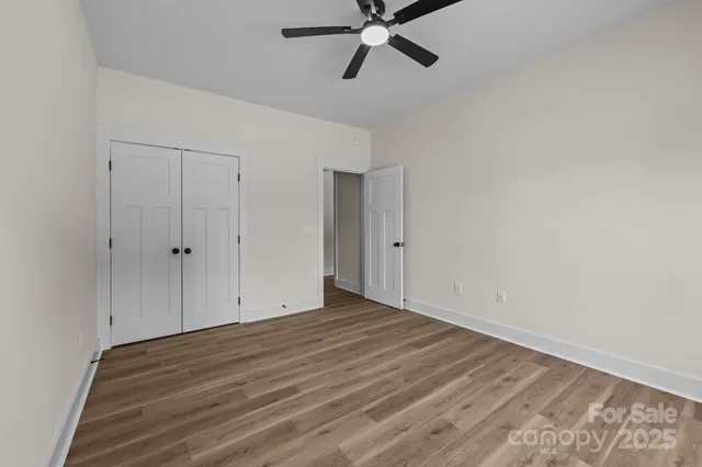 a view of an empty room with wooden floor
