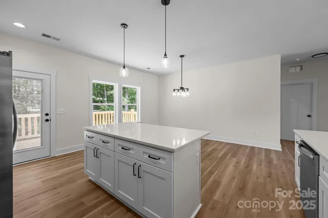 a kitchen with kitchen island a sink stove and wooden floor