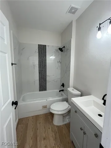 a bathroom with a sink a toilet a mirror and shower