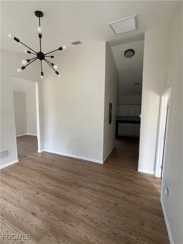 a view of a room with wooden floor and a ceiling fan