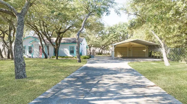 a front view of a house with a garden and trees
