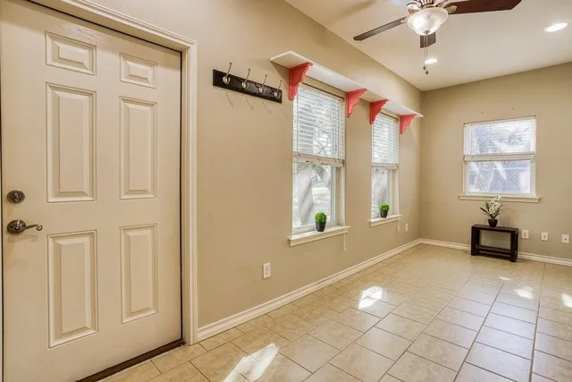 a view of an entryway with a chandelier fan and windows