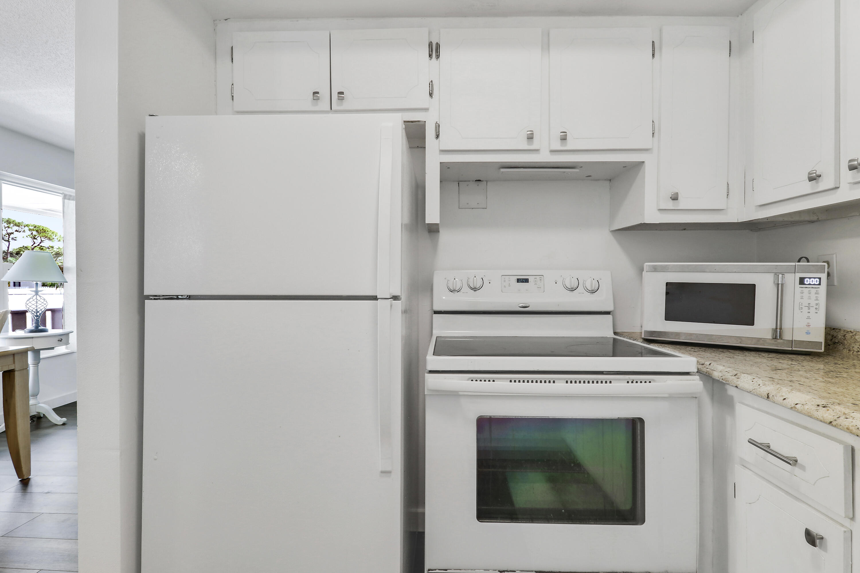 2929 Southeast Ocean Boulevard, Unit I9 Stuart, FL 34996 - Photo 11 of 19 a white refrigerator freezer and a stove sitting inside of a kitchen