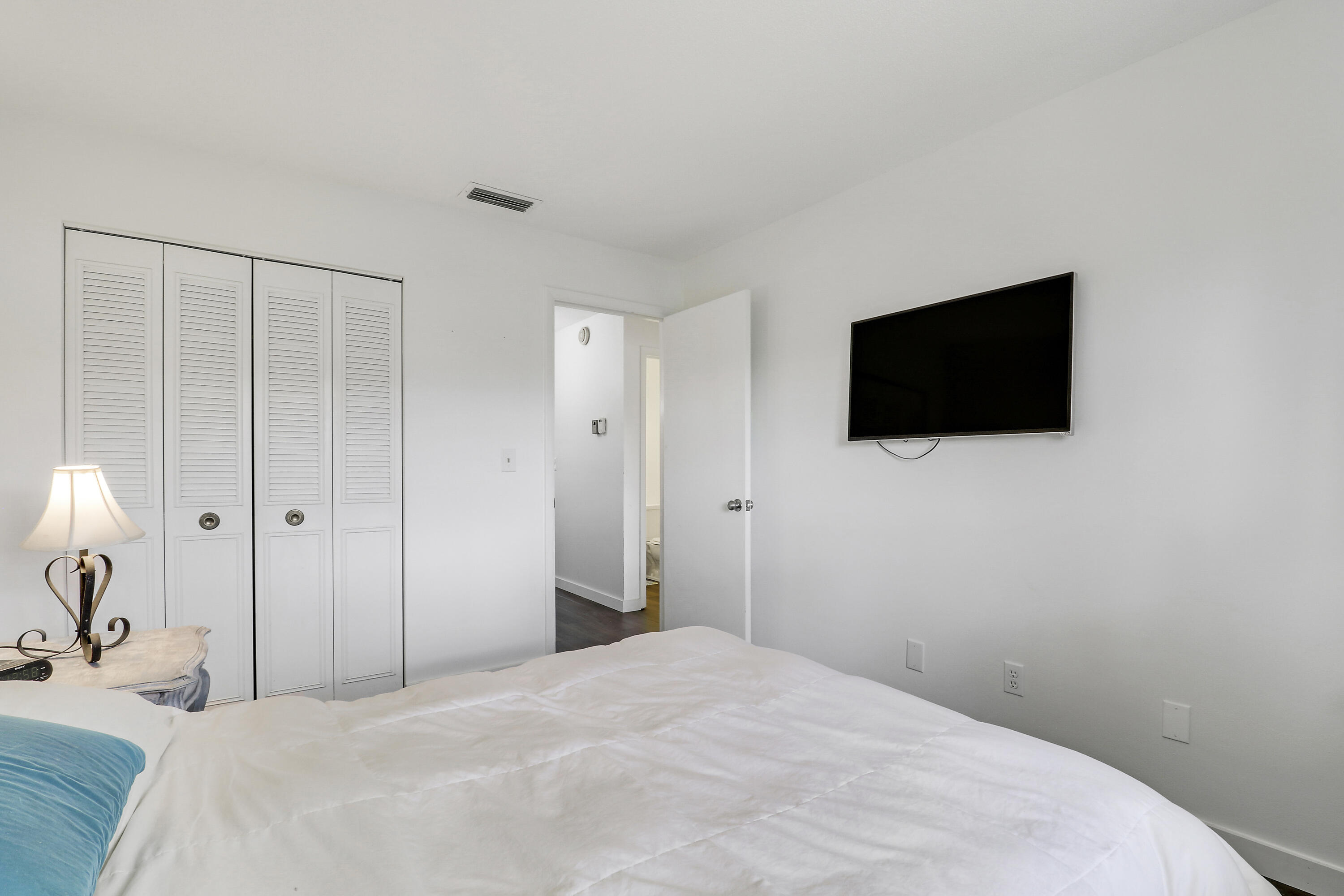 2929 Southeast Ocean Boulevard, Unit I9 Stuart, FL 34996 - Photo 14 of 19 a bedroom with a bed and a flat screen tv
