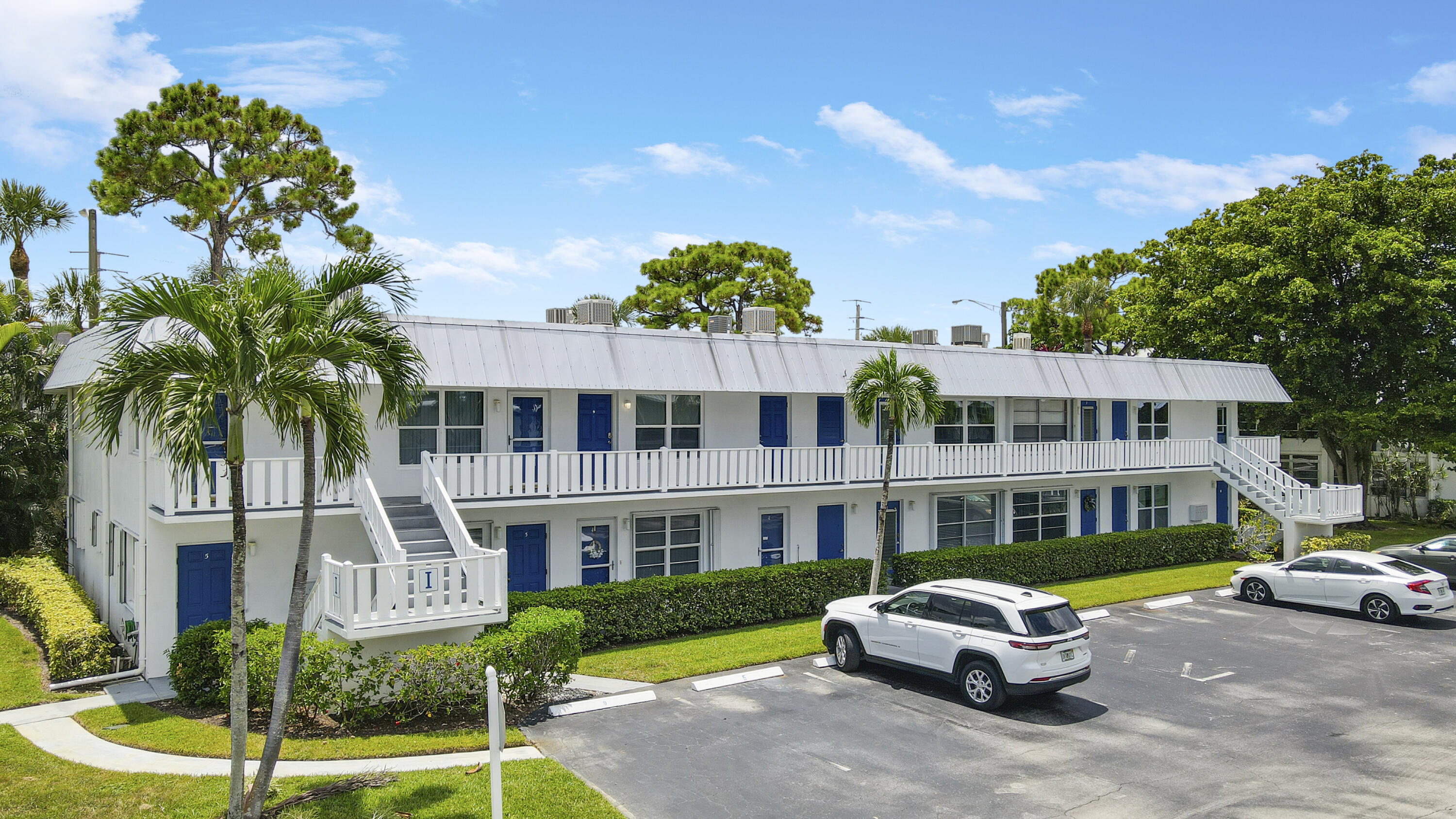 2929 Southeast Ocean Boulevard, Unit I9 Stuart, FL 34996 - Photo 2 of 19 a front view of a house with a garden and swimming pool