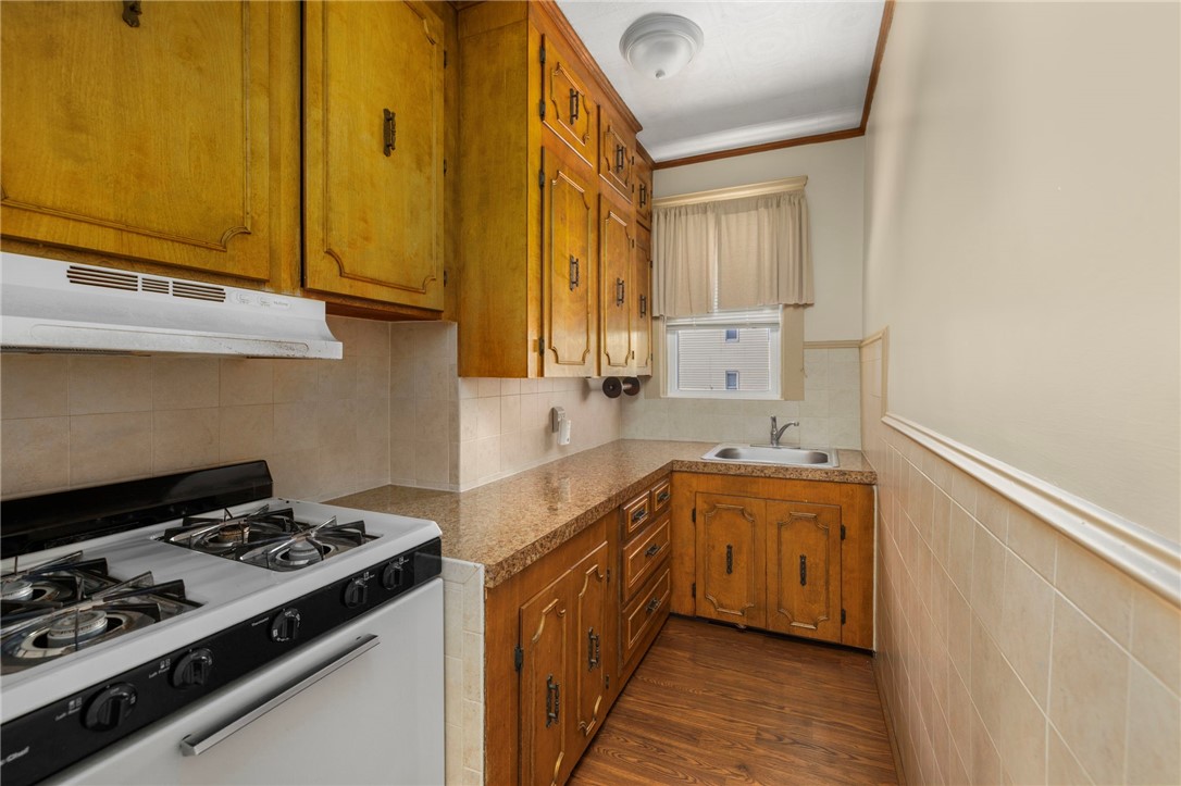 20 Gridley Street Providence, RI 02904 - Photo 24 of 50 Unit 2: Galley style kitchen with gas range, laminate counters & flooring, tiled backsplash