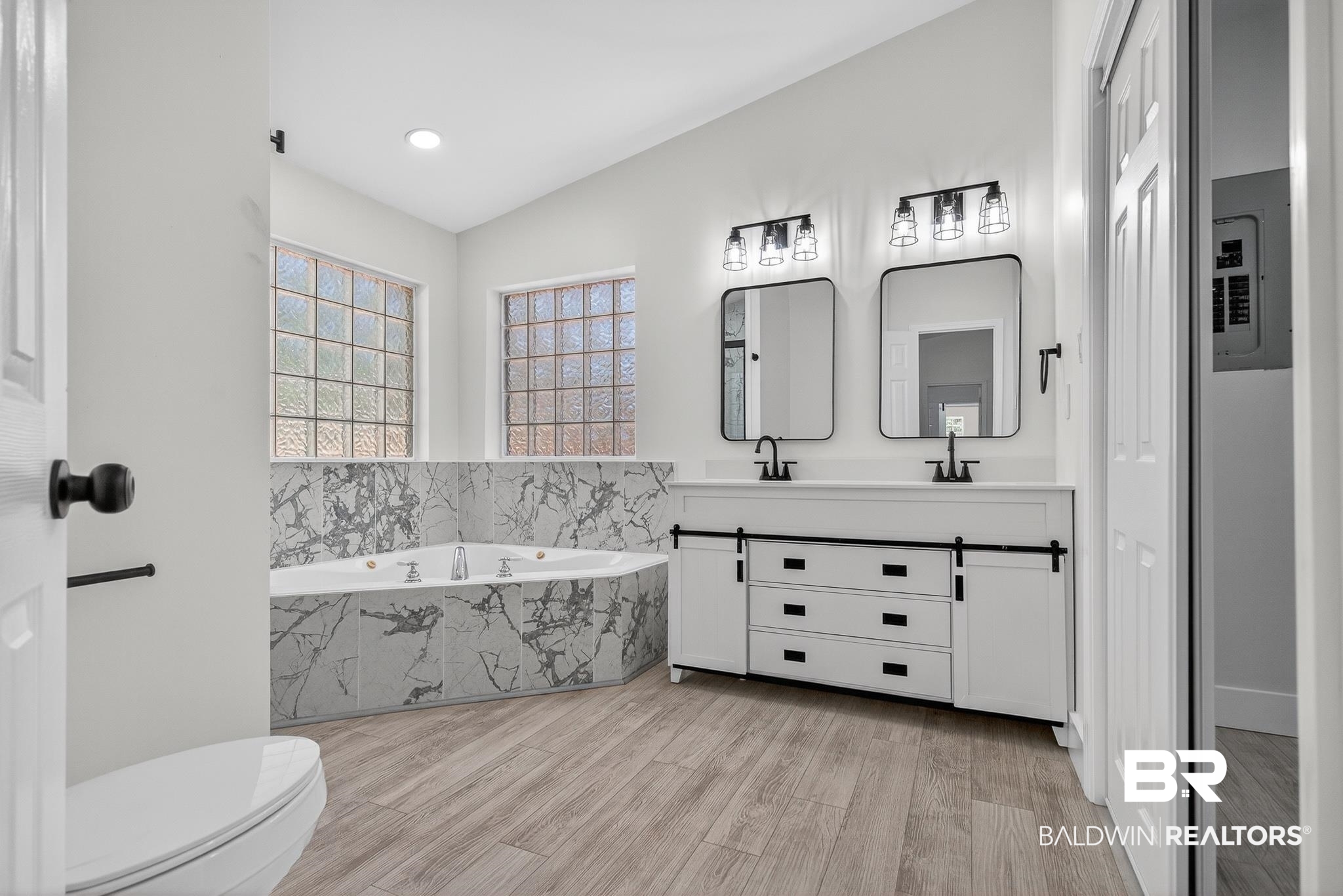 10650 Old Pascagoula Road Theodore, AL 36582 - Photo 65 of 77 Full bath featuring double vanity, a garden tub, electric panel, light wood-style flooring, and lofted ceiling