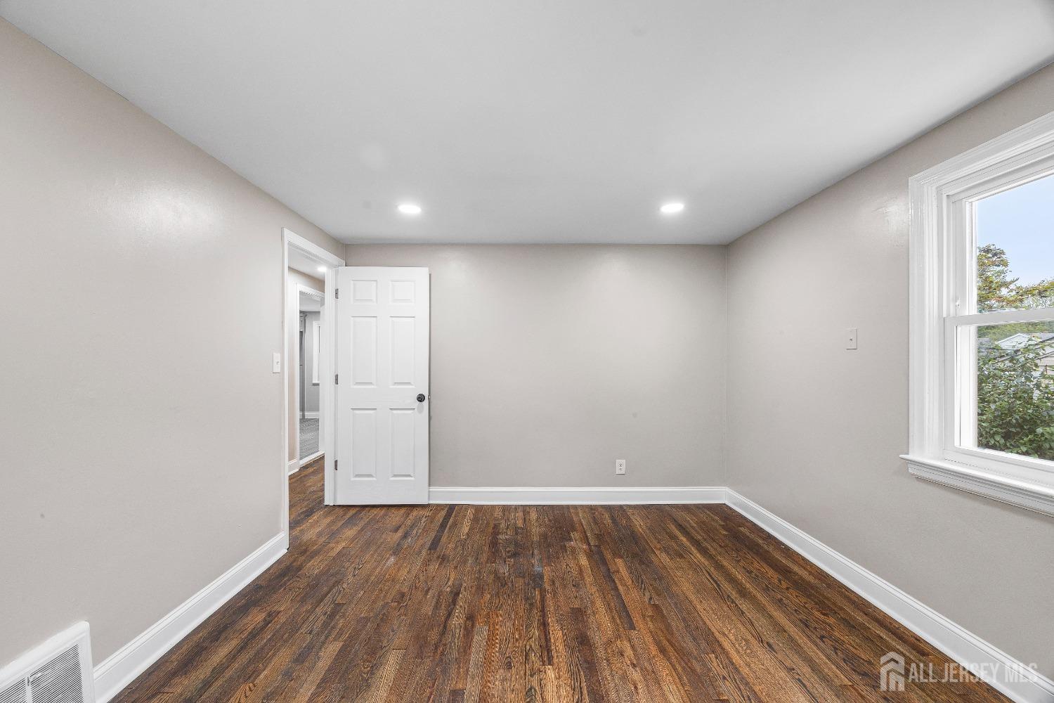 92 Highfield Road Colonia, NJ 07067 - Photo 12 of 25 an empty room with wooden floor and windows