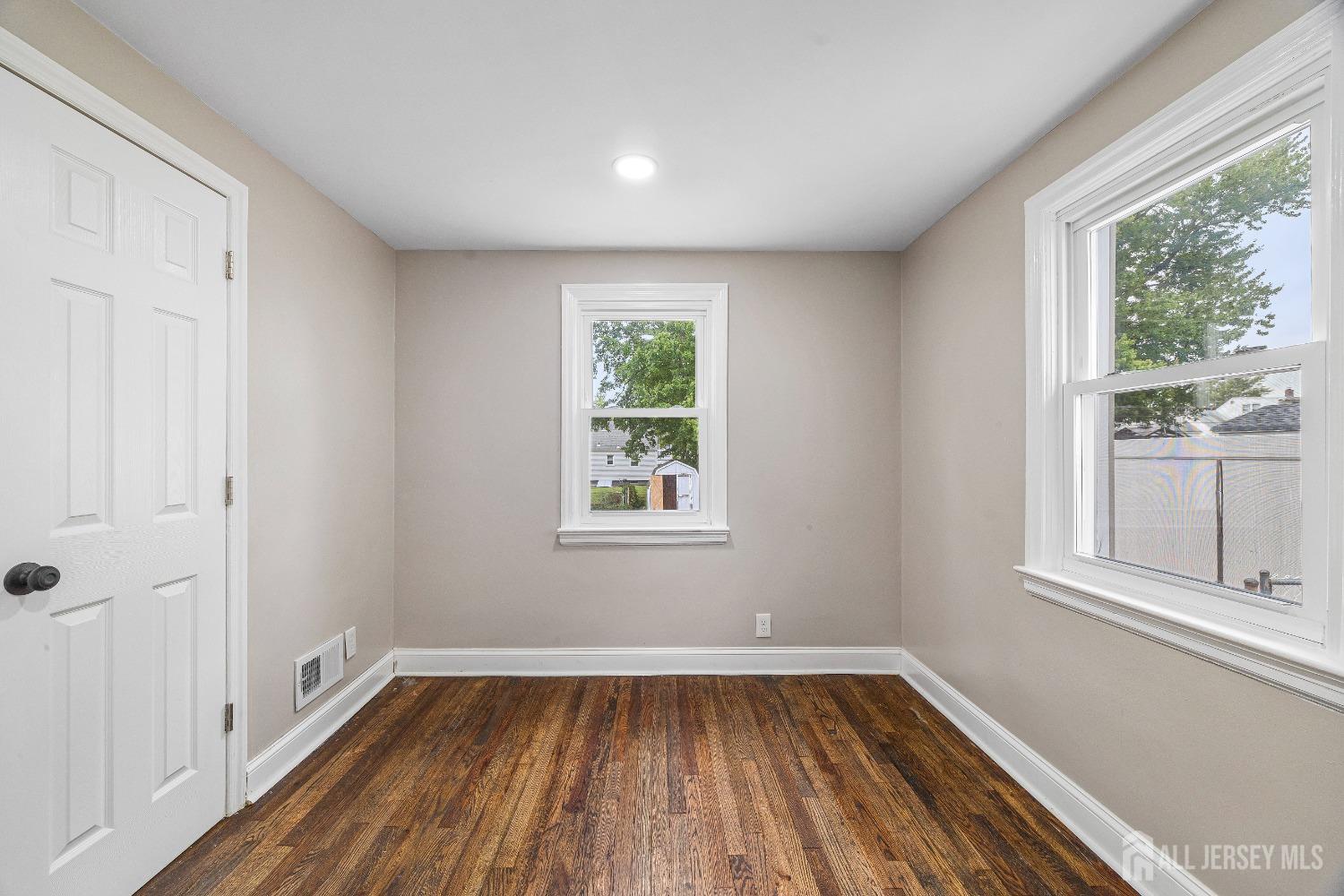 92 Highfield Road Colonia, NJ 07067 - Photo 13 of 25 a view of an empty room with wooden floor and a window