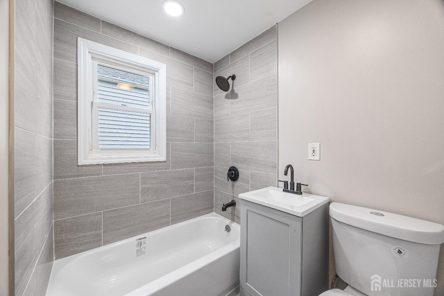 92 Highfield Road Colonia, NJ 07067 - Photo 17 of 25 a bath room with a toilet a sink and a bath tub