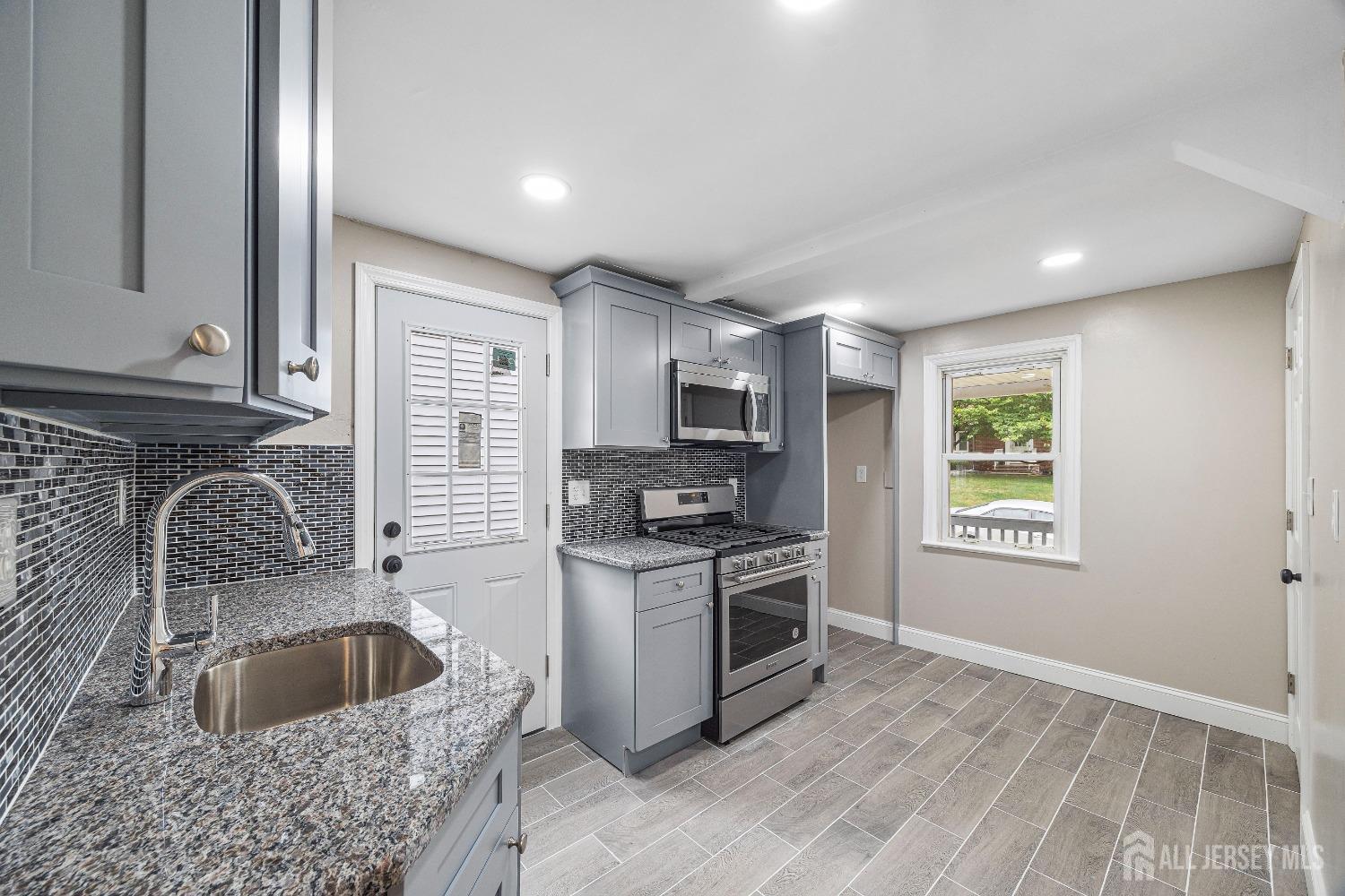 92 Highfield Road Colonia, NJ 07067 - Photo 10 of 25 a kitchen with a stove a sink and a microwave