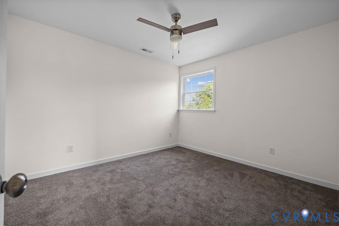 11325 Webb Road Disputanta, VA 23842 - Photo 22 of 32 an empty room with a window and a ceiling fan