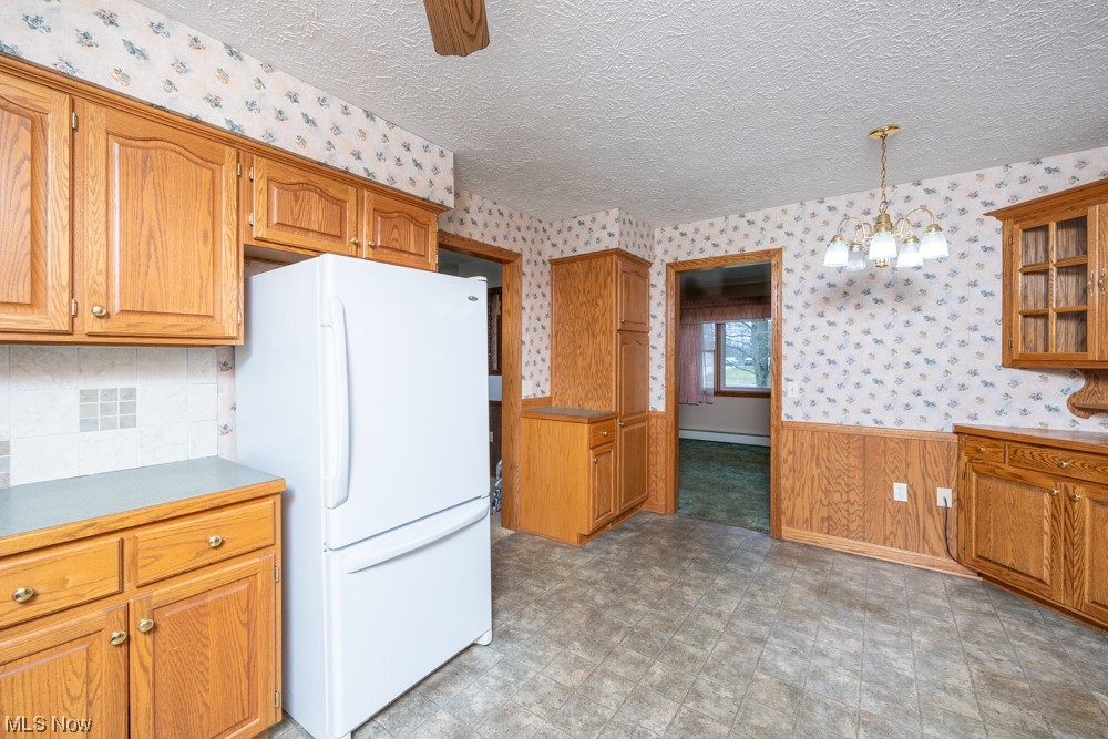 4251 Seville Road Seville, OH 44273 - Photo 5 of 20 Kitchen with laminate floors, white refrigerator, a baseboard radiator, and decorative light fixtures