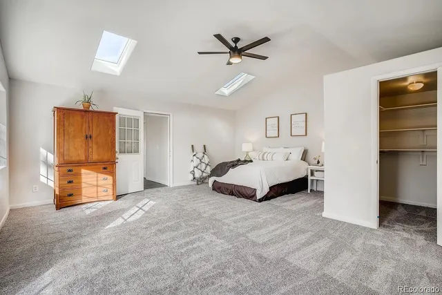 a spacious bedroom with a bed and a ceiling fan