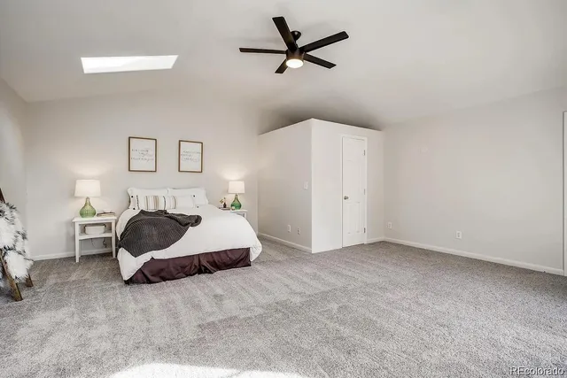 a spacious bedroom with a bed and a ceiling fan