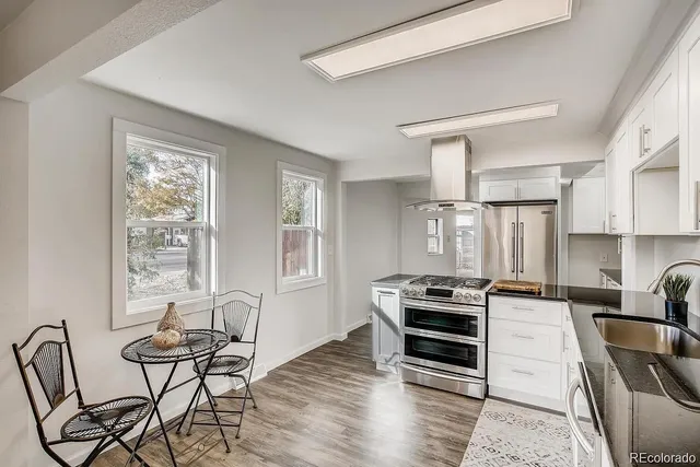 a kitchen with granite countertop a stove and a wooden floors